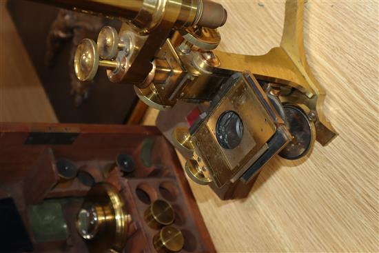 A Victorian brass scientific microscope by Ross, London, boxed with a case of slides